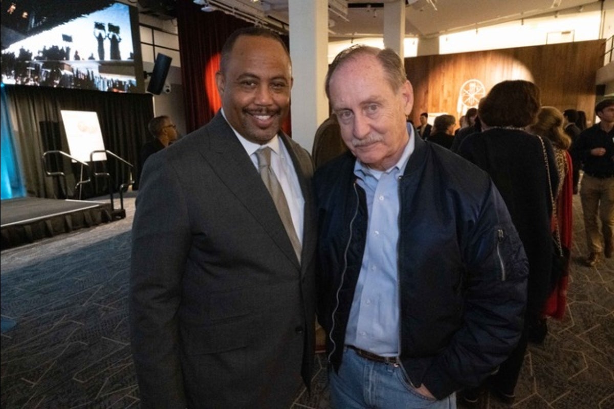 Two men posing for a photo at a media party.