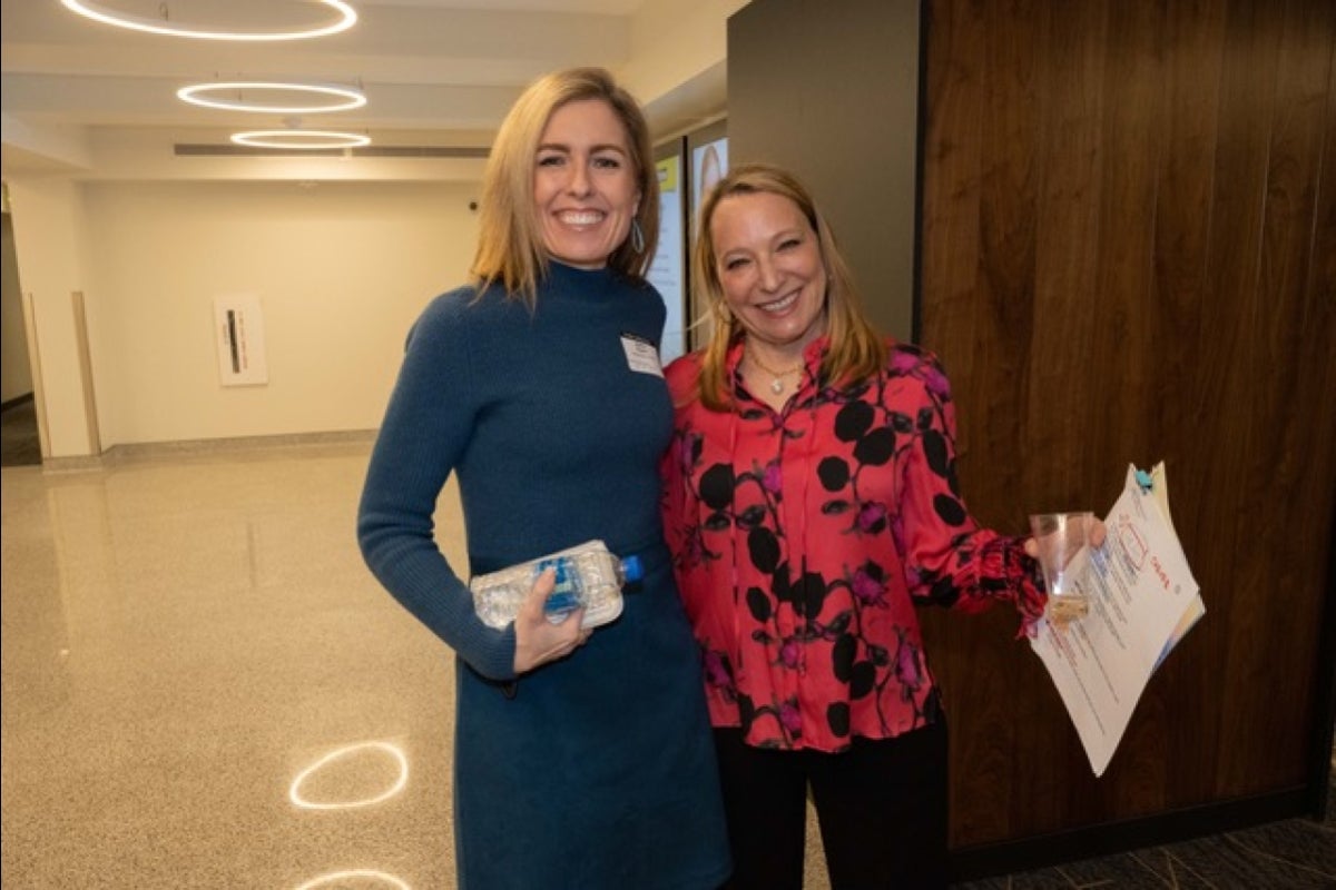 Two women smiling and posing for a photo at a media party.