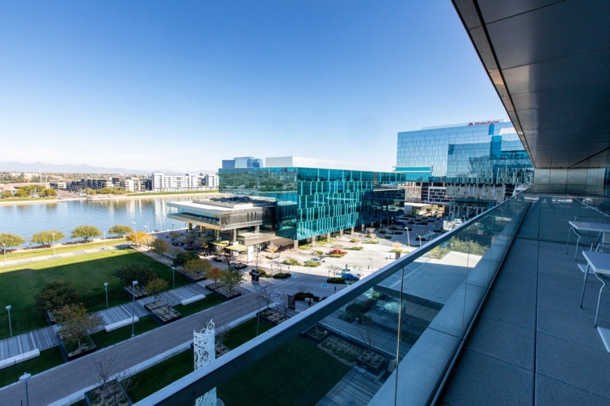 View from a balcony in one of State Farm's buildings at Marina Heights in Tempe, overlooking a lake and other nearby buildings.