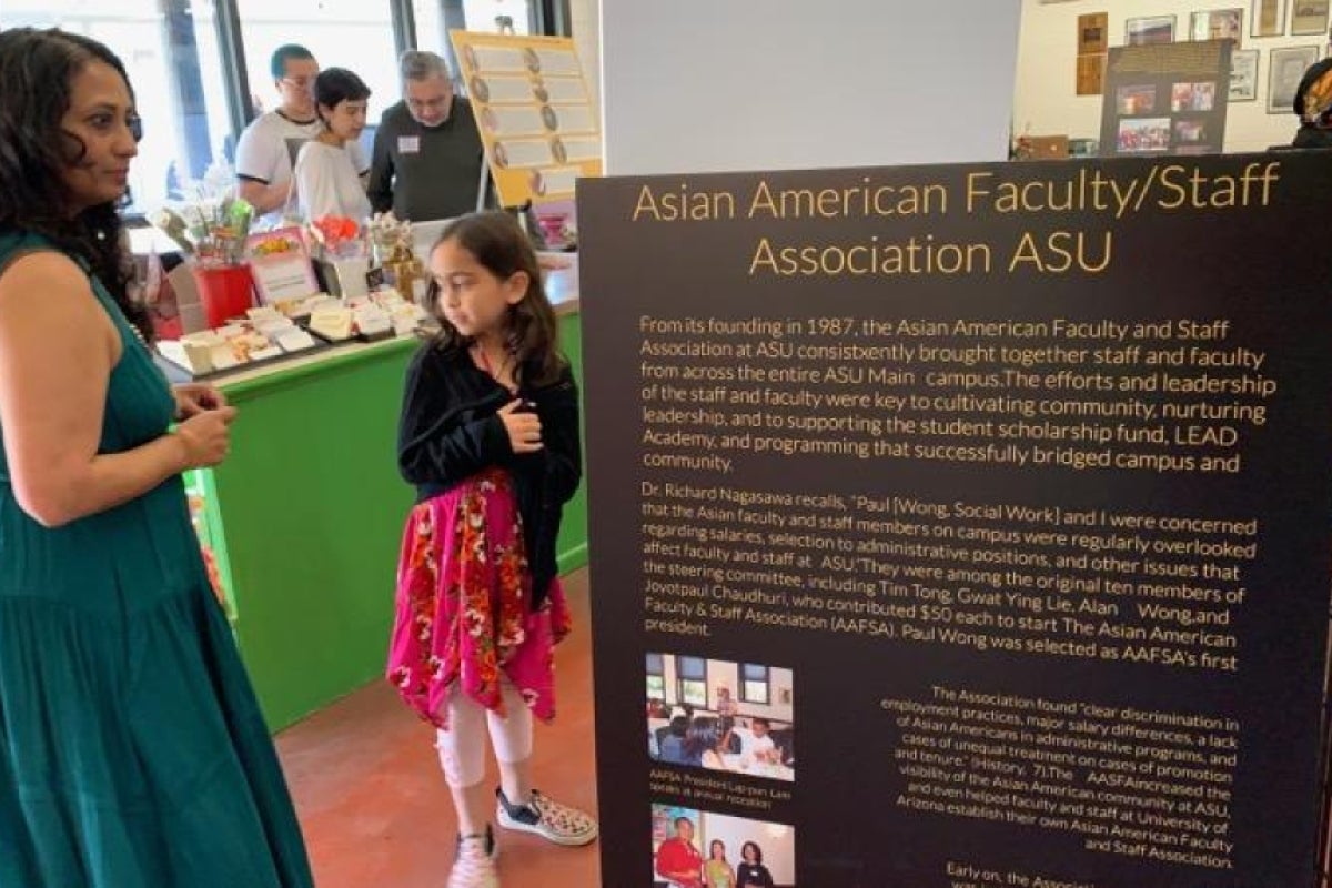 Person and child standing by a sign that reads 