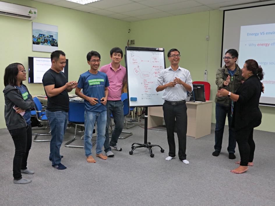 seven people standing in a room laughing