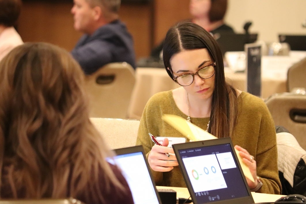 woman sitting at a table looking at papers