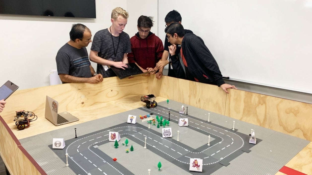 Students stand behind a track