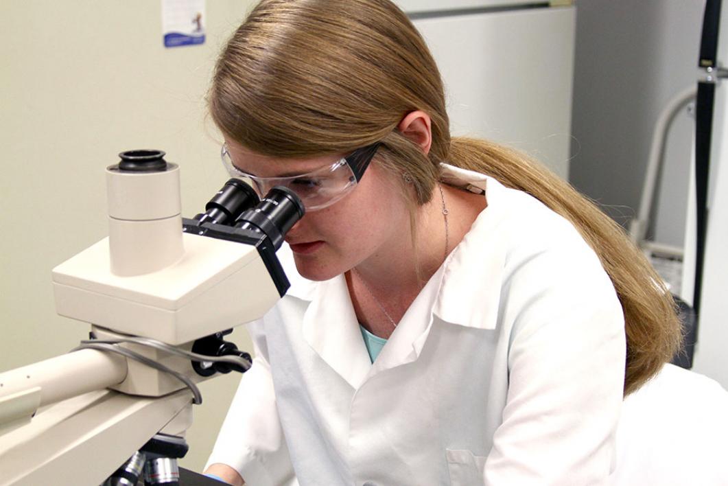 student looking through microscope