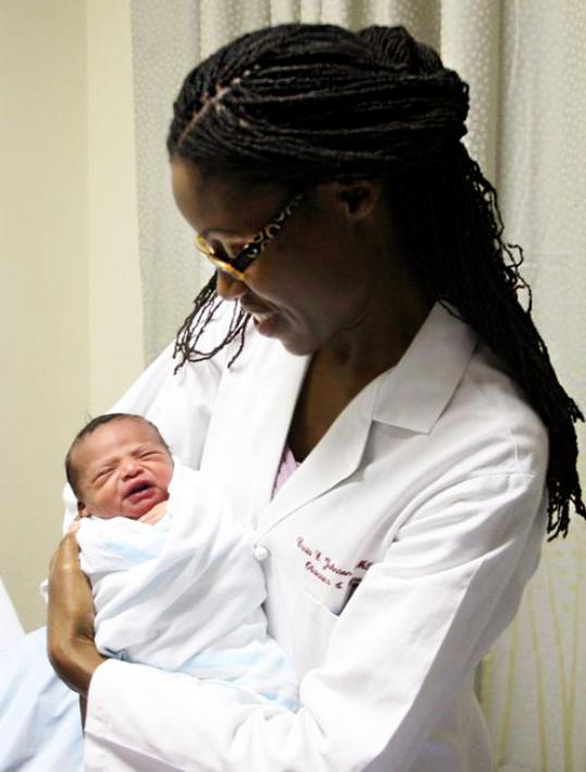 Dr. Johnson-Agbakwu cradles a newborn baby birthed at the clinic