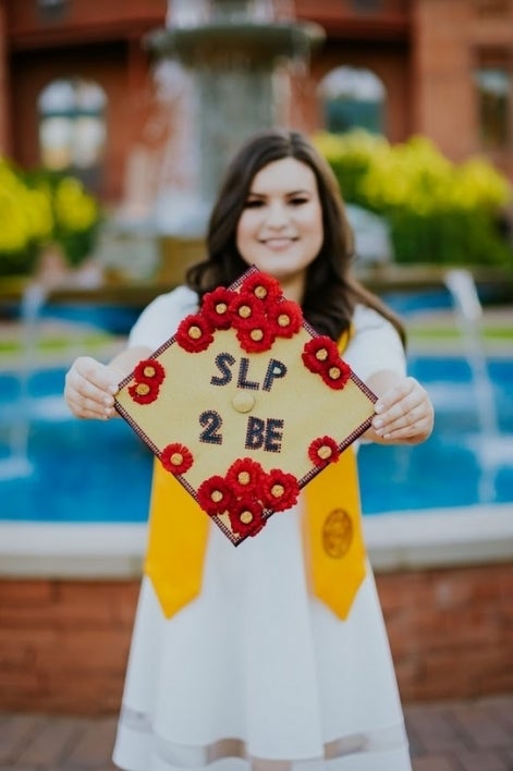 woman holding graduation cap that says 