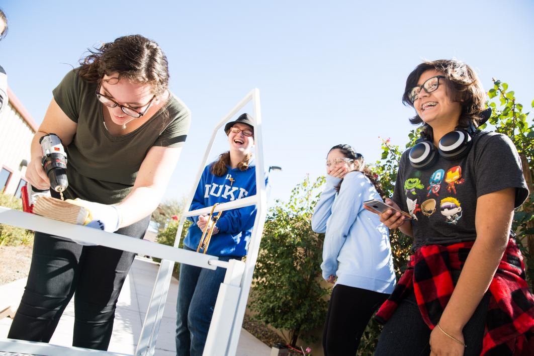 girls drill a piece of metal