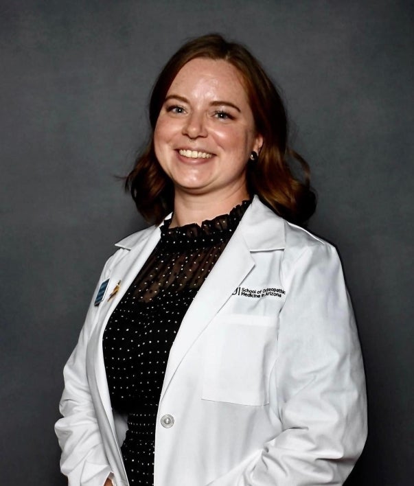 woman wearing white coat as she graduates from ASU's College of Heatlh Solutions