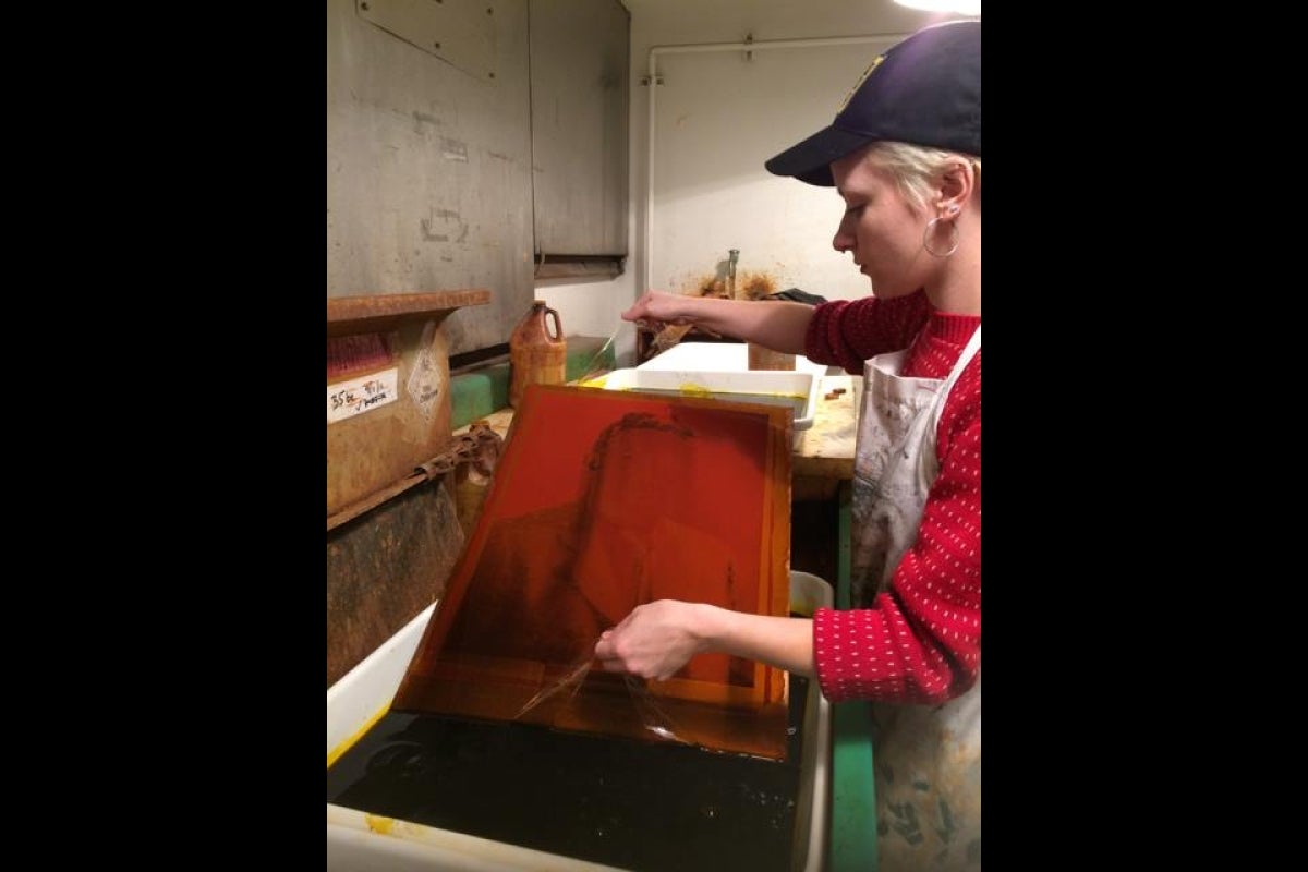 Student Lauren Kelly etching a large photogravure for artist Sarah Sense