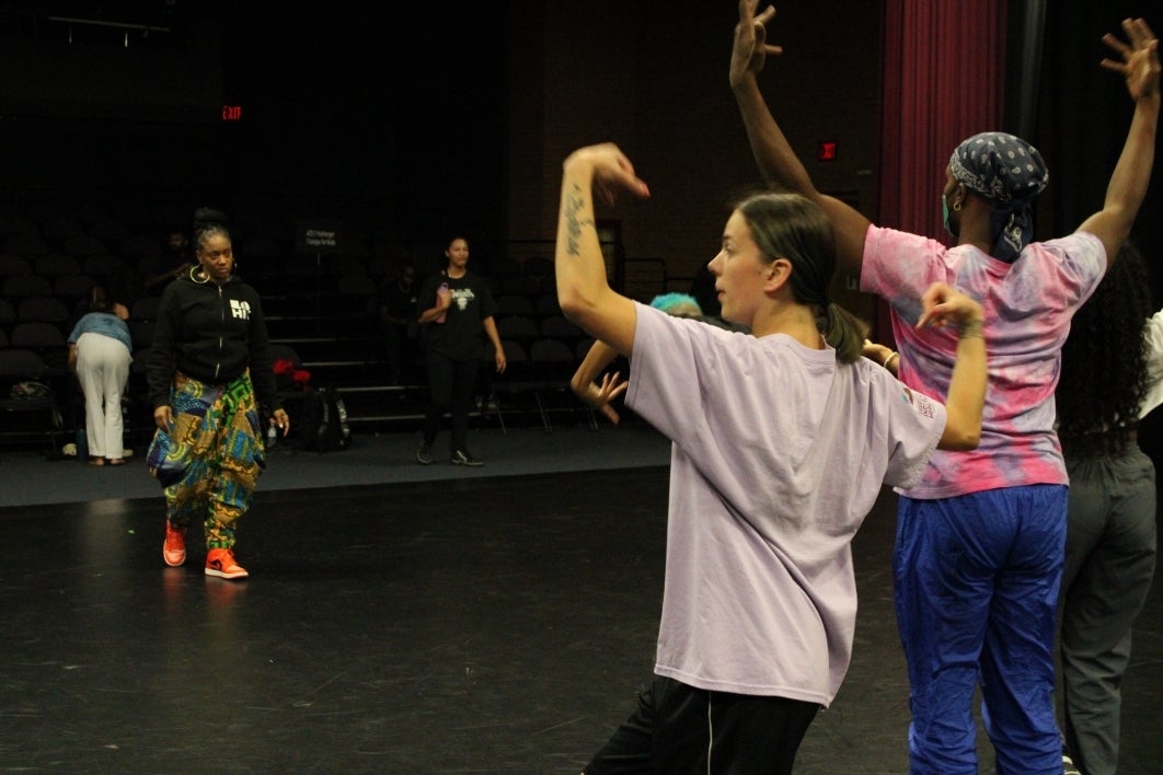 People rehearse a dance performance onstage.