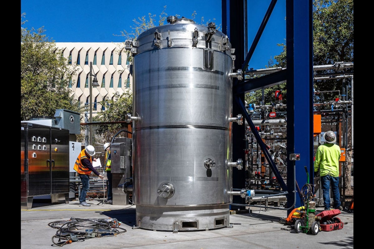 Workers installing a large cylindrical container