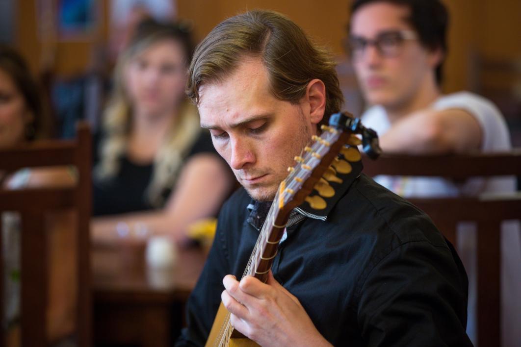 A student plays the vihuela at the Chaucer Celebration.