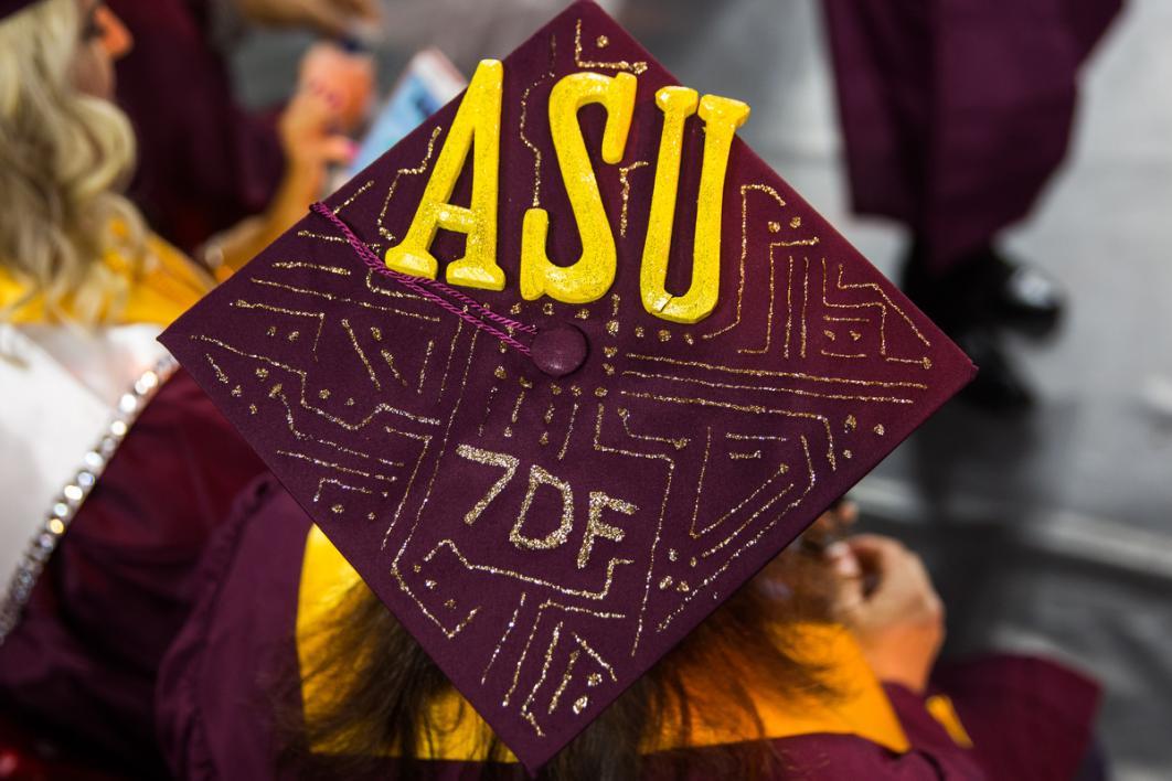 A graduation cap is covered in glitter lines and the text, 