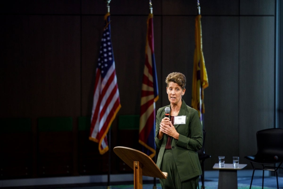 Sally C. Morton stands at a podium with a microphone.