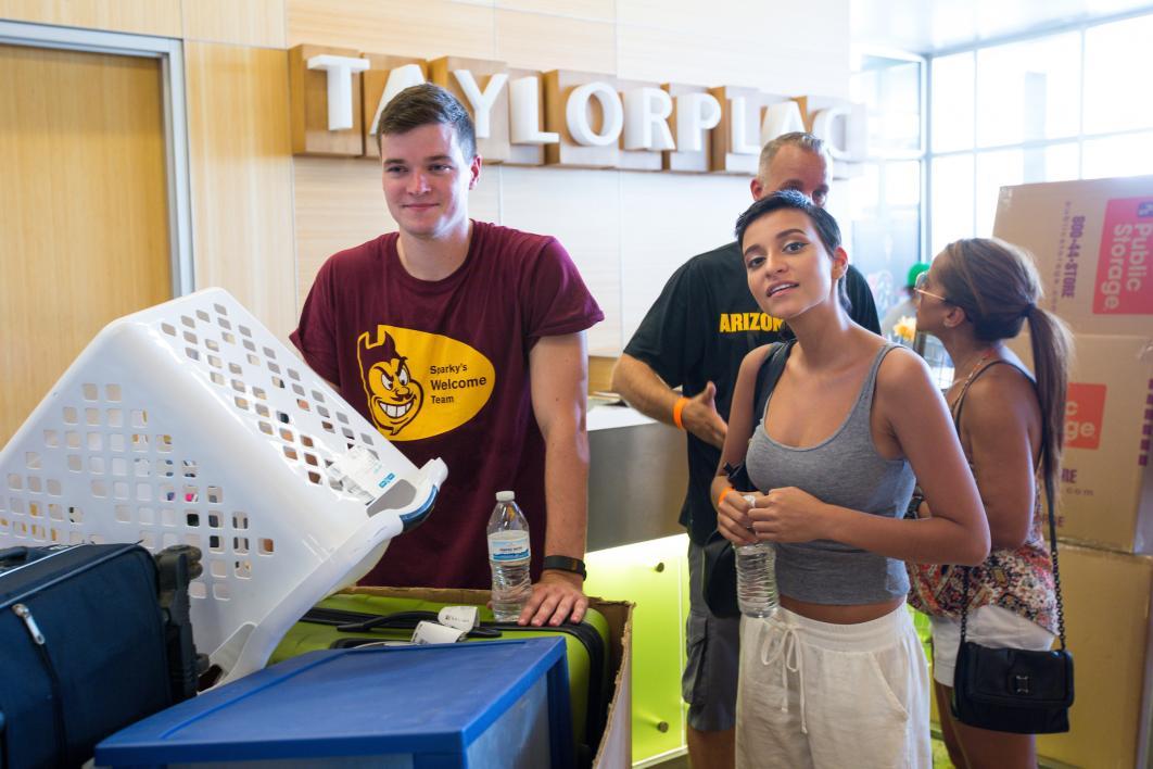 A new student waits with her belongings to move into the downtown dorm.