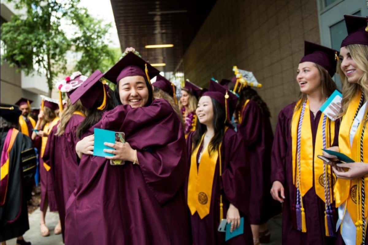 two graduates hugging at convocation