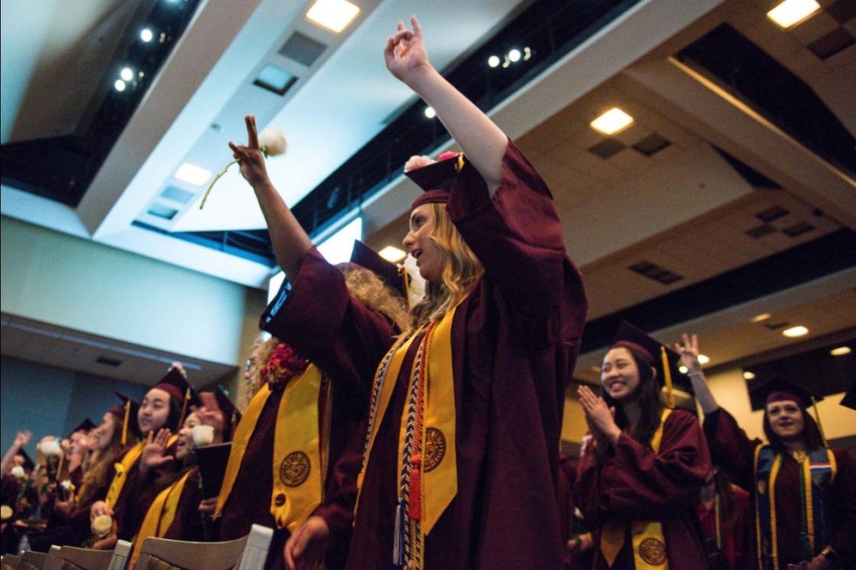 two graduates cheering