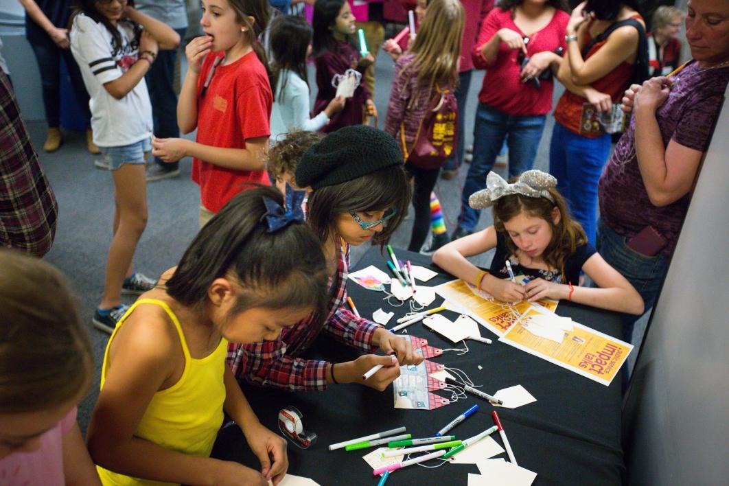 Children play with arts and crafts supplies.