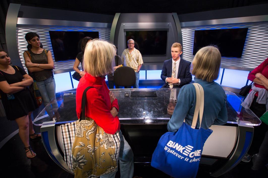 Visitors at the news anchor desk at Cronkite.