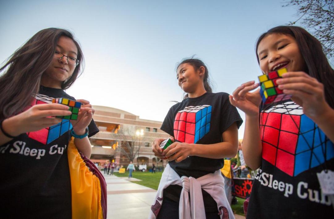 girls holding rubiks cubes