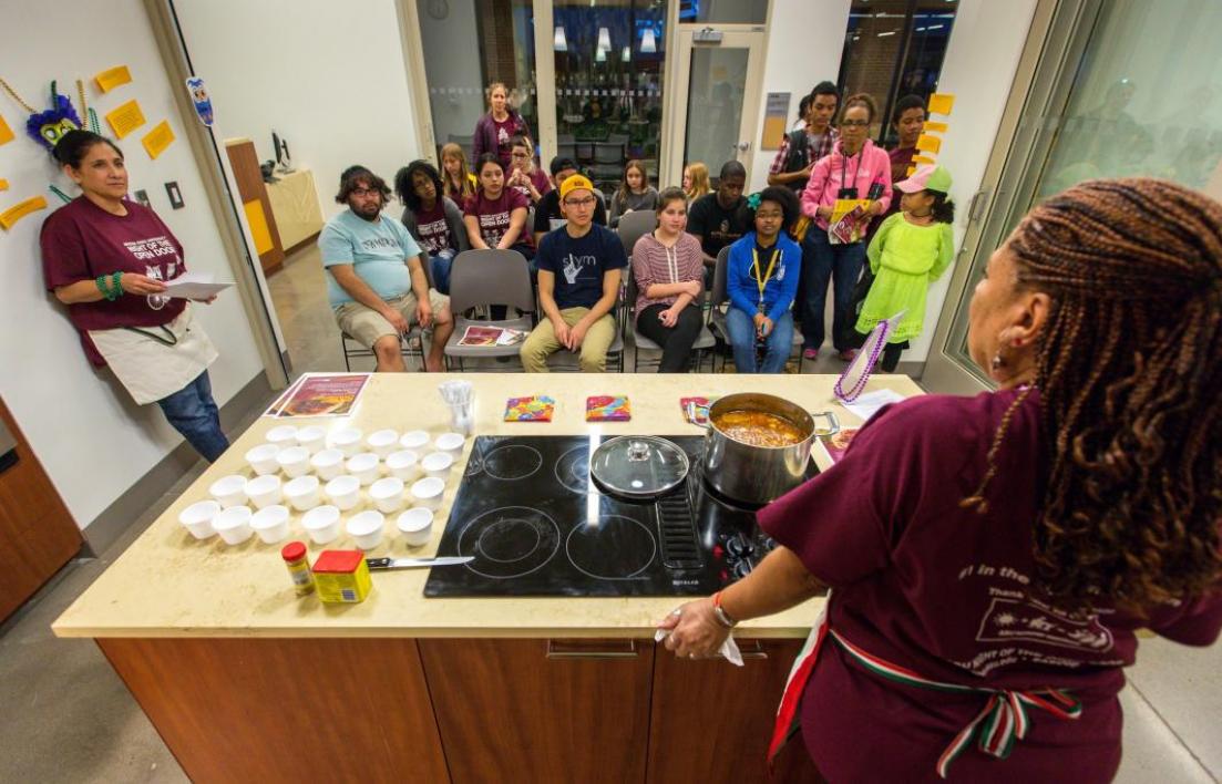 woman making gumbo in front of group