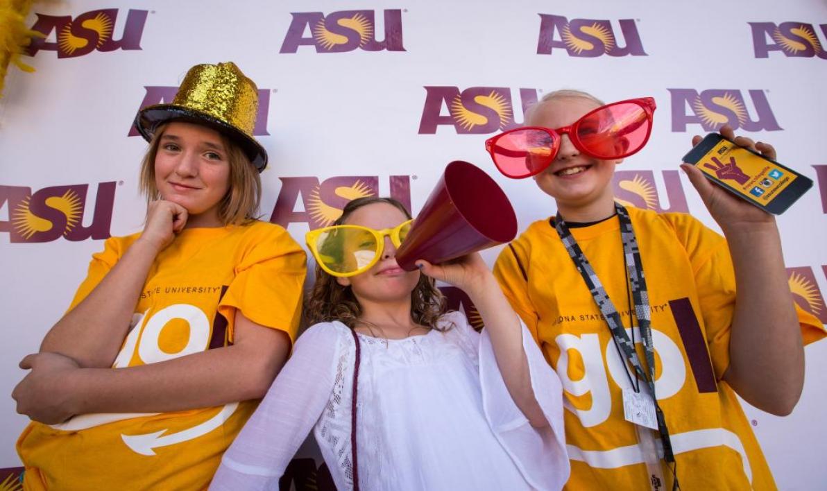 girls getting their photo taken wearing props