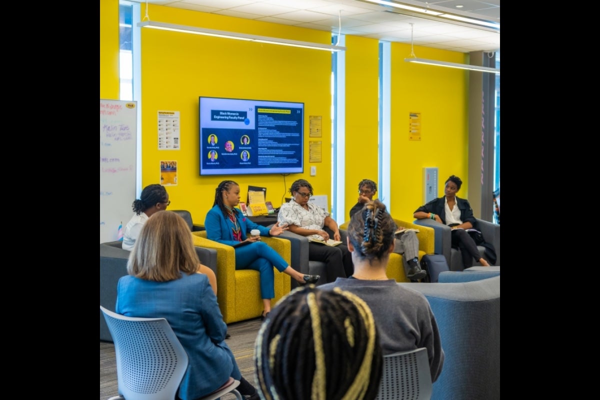 STEM Panel speaks to students in an informal setting, sitting in a circle in chairs.