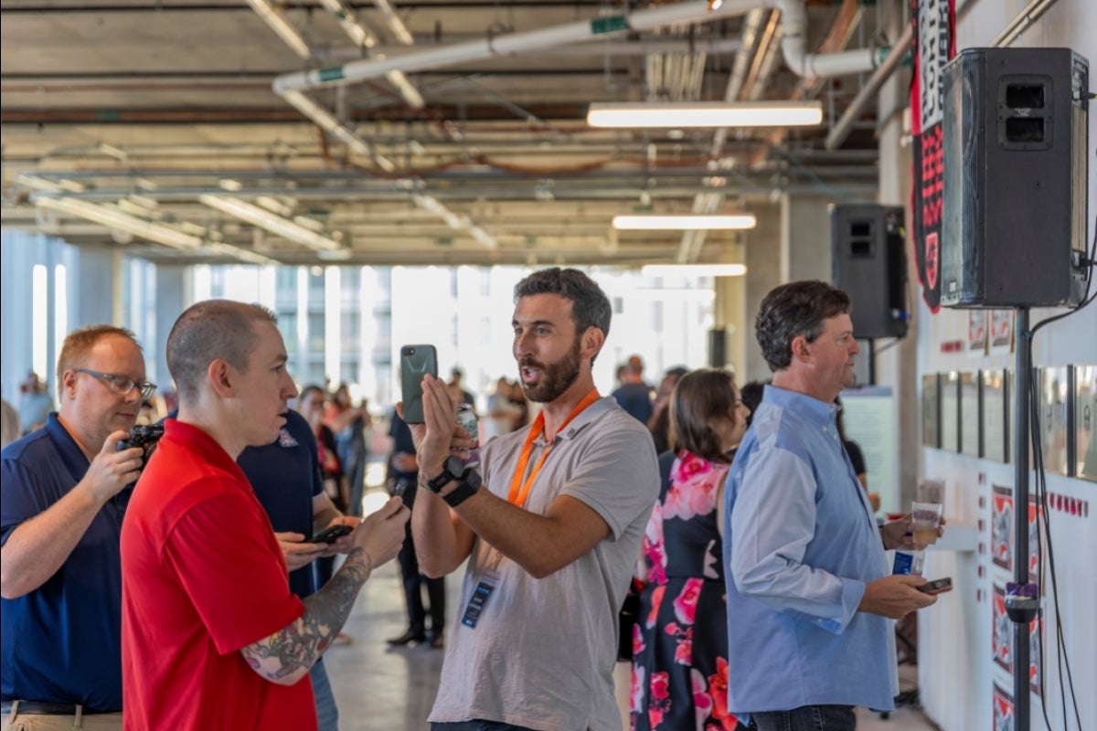 People speaking at an art exhibition.