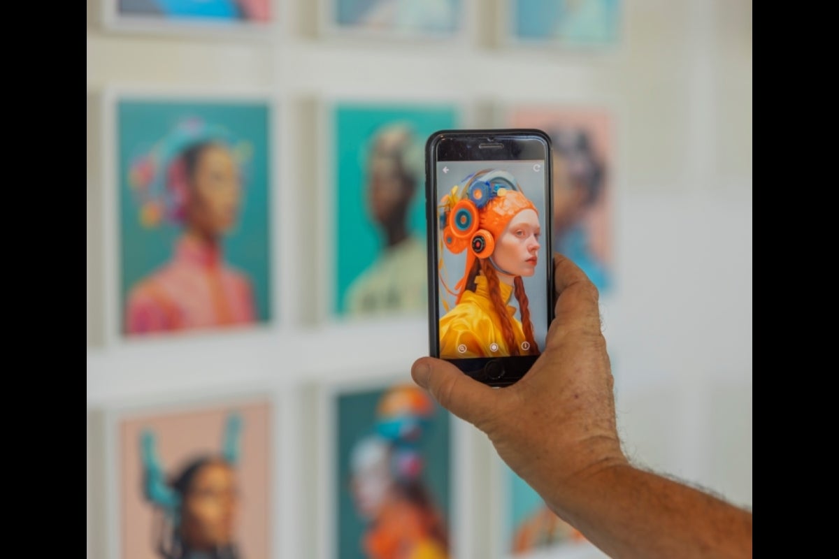 Outstretched arm holding a cellphone showing an image of a person wearing a futuristic health device.