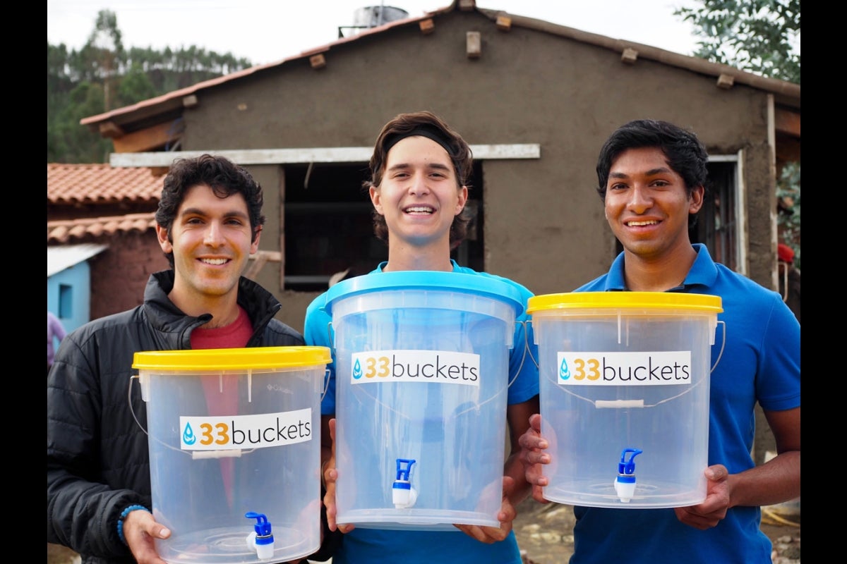 Mark Huerta, Vid Micevic and Swaroon Sridhar of 33 Buckets pose with their water containers in Peru