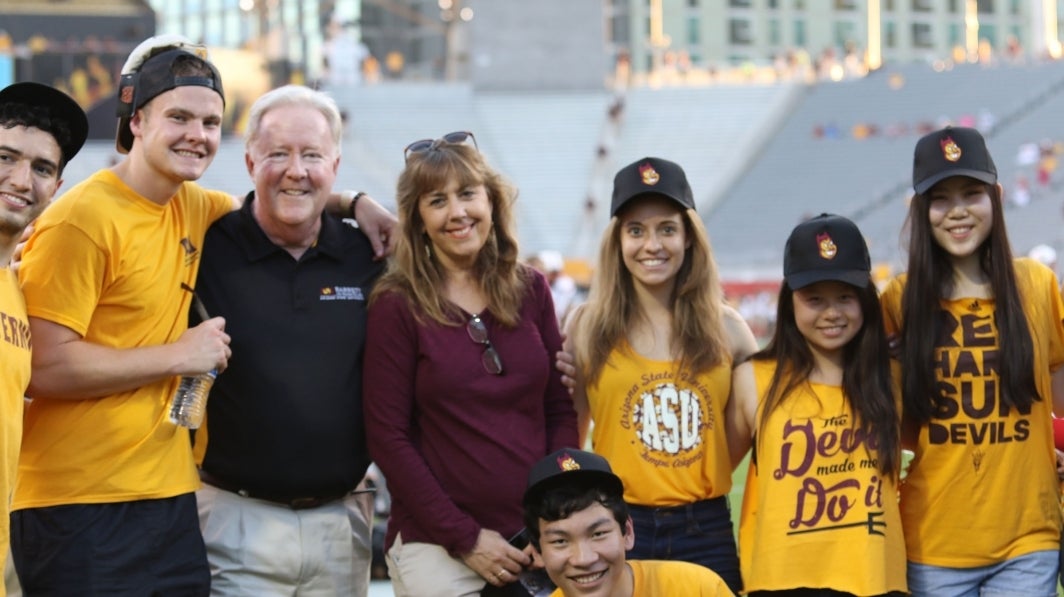 A group of people pose for a photo at a football game