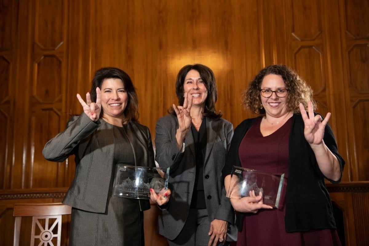 ASU Provost Nancy Gonzales, Cathryn Rivera and Katie Orr smiling and posing with forks-up hand signs.