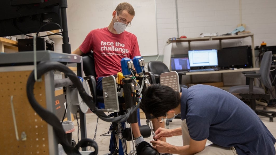 Connor Phillips tests a robotic device with Hyunglae Lee.