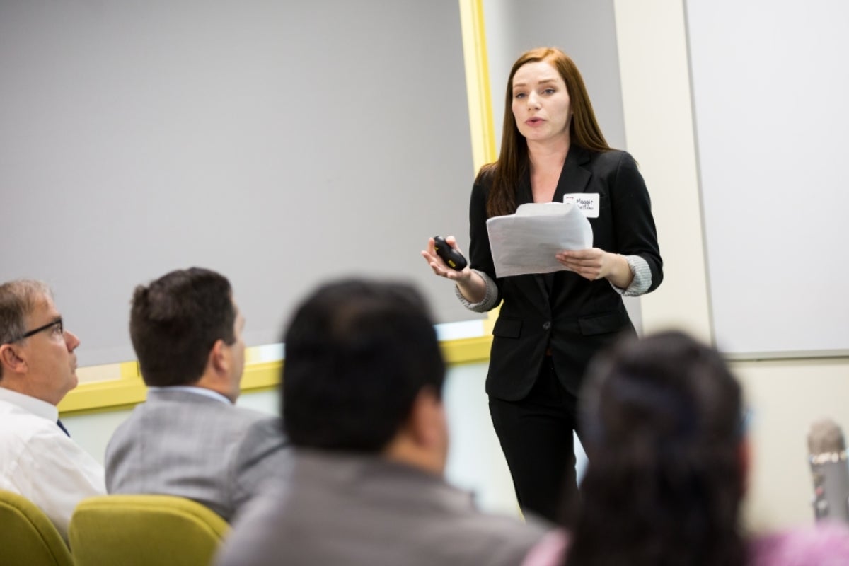 Woman in professional wear, Maggie Dellow, giving presentation