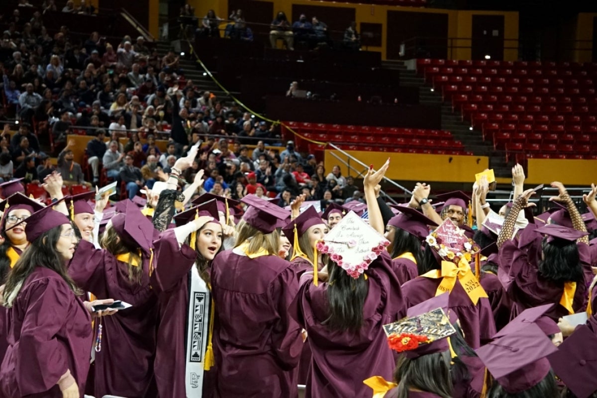 Graduates of ASU's Watts College of Public Service and Community Solutions wearing graduation regalia and celebrating at their graduation ceremony.