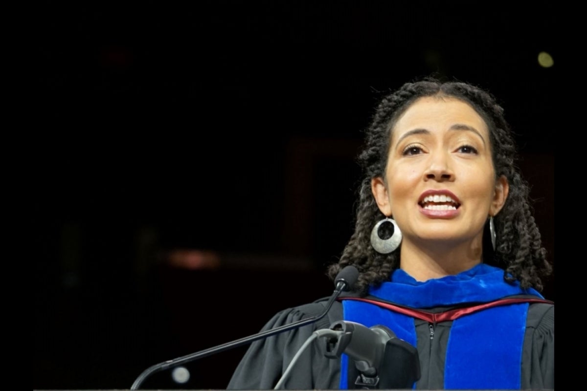 Woman speaking into a microphone behind a lectern.