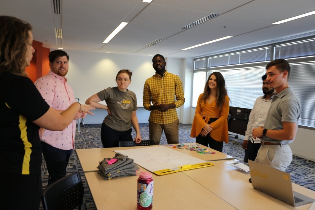 A group of students discuss ideas around a table