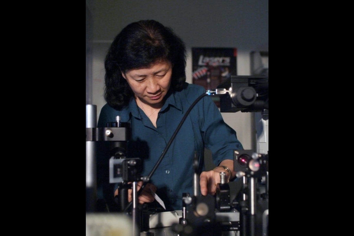 Su Lin working in a lab, looking down.