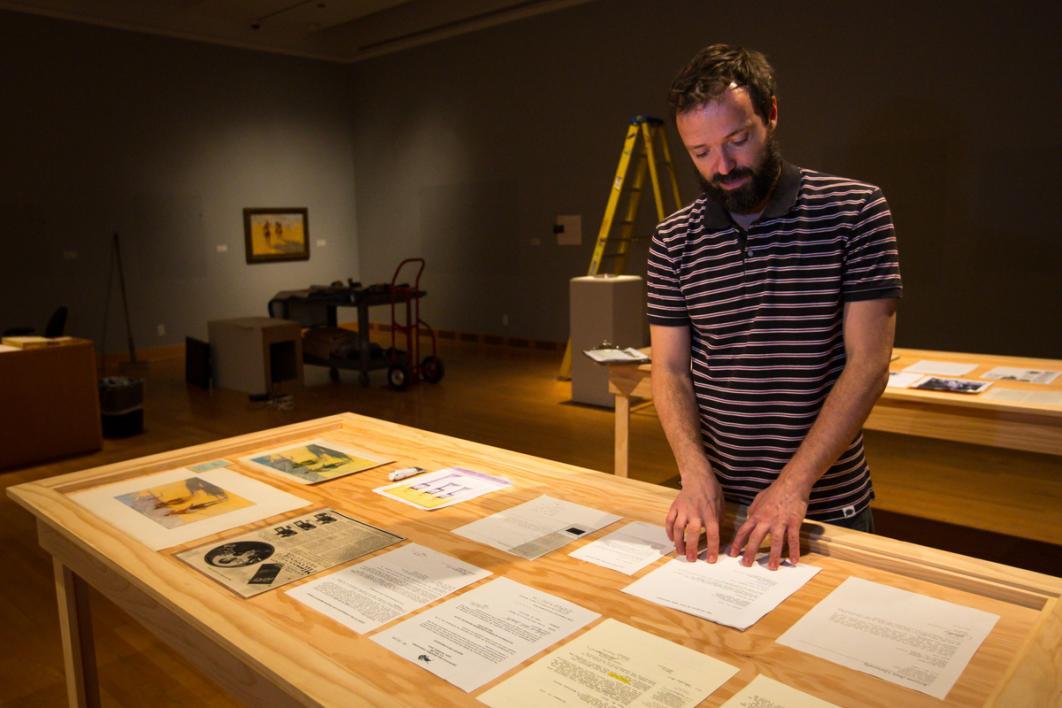 Man looking at documents in a gallery.