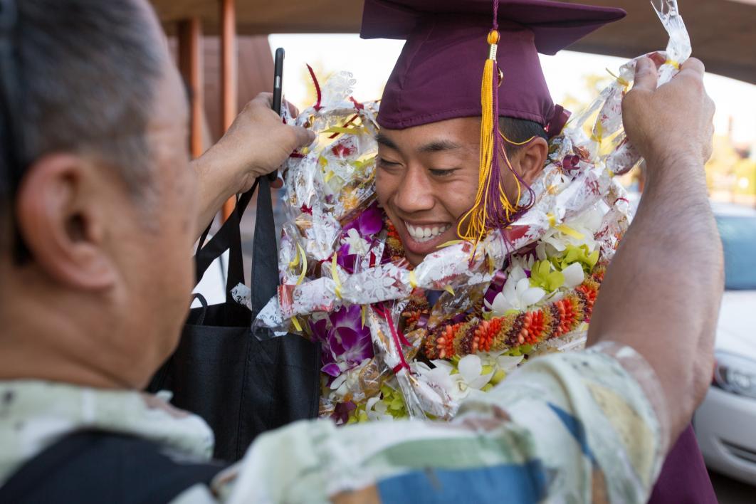 father giving graduate lei