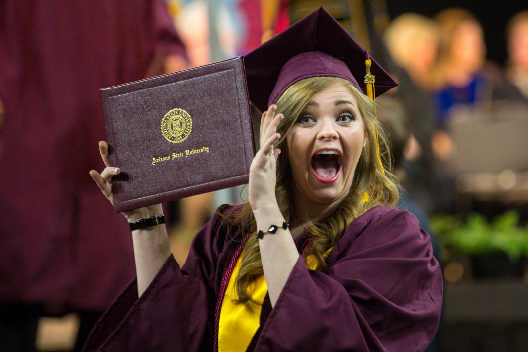 student holding up diploma