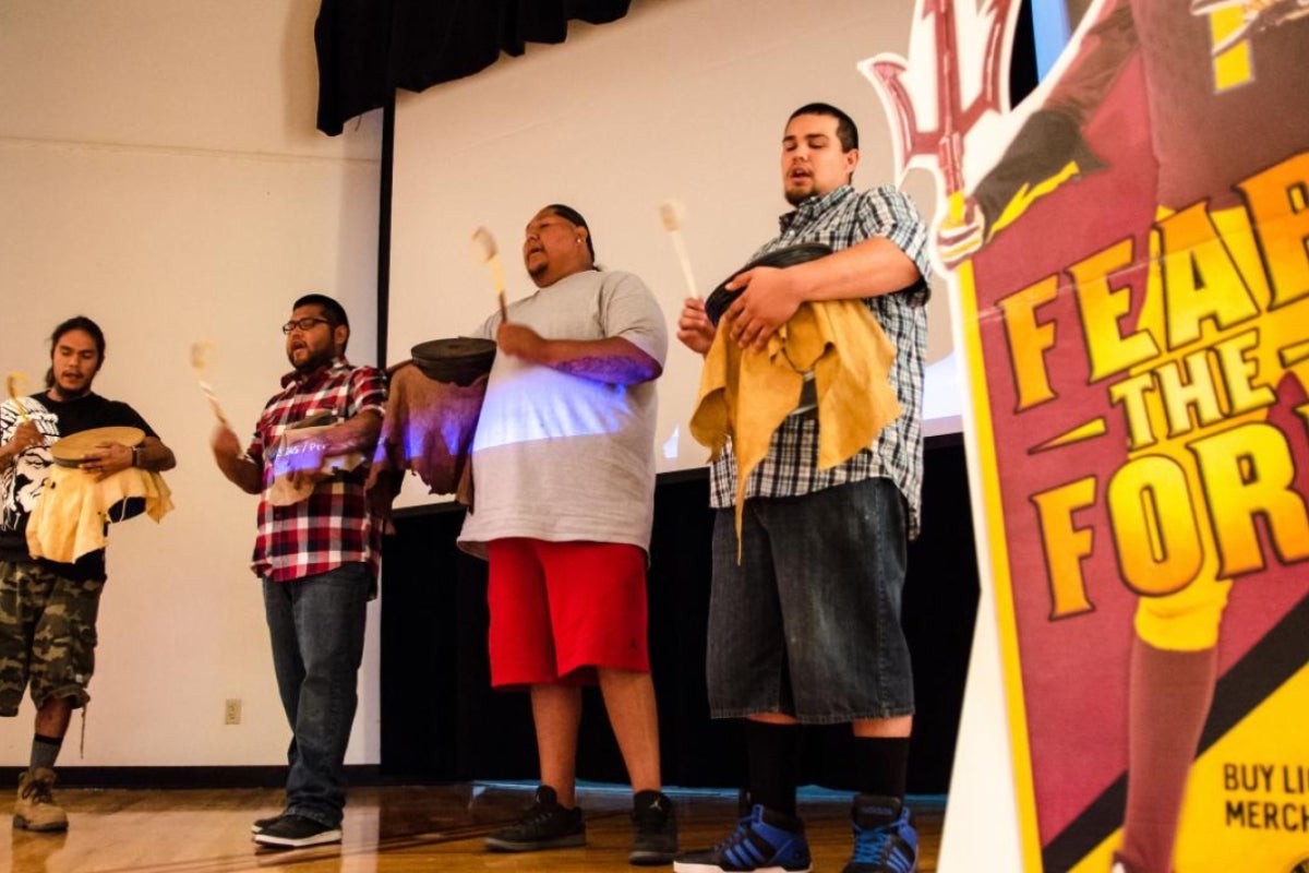 People perform traditional Native drumming and singing