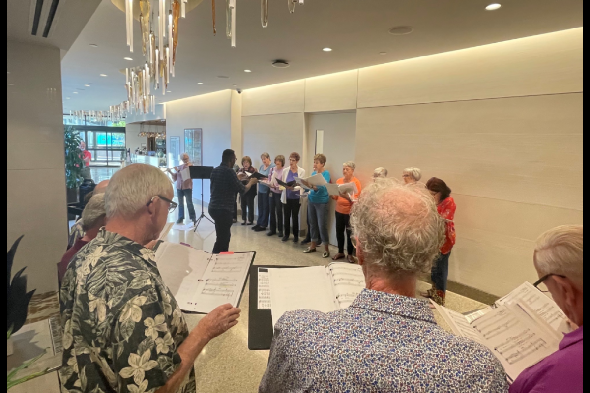 People standing in a hallway looking at music sheets.