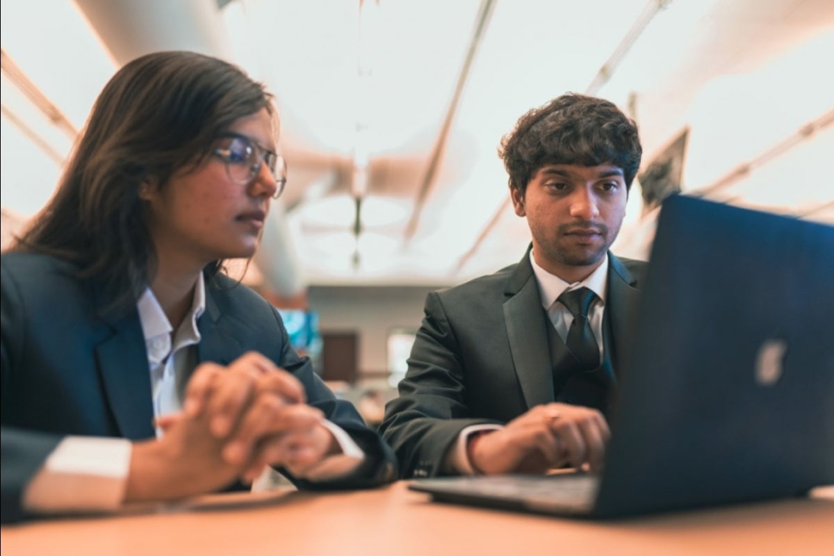 Two students work on a laptop