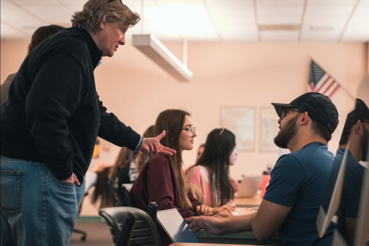 Instructor discusses a project with a student inside a classroom.