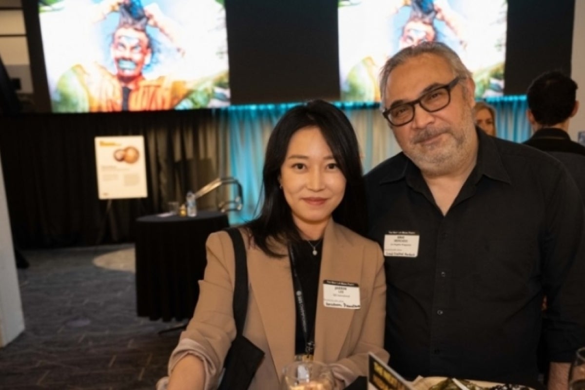 Two people posing for a photo at a media party.