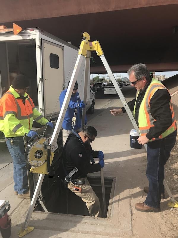 Municipal wastewater personnel remove automatic wastewater sampler