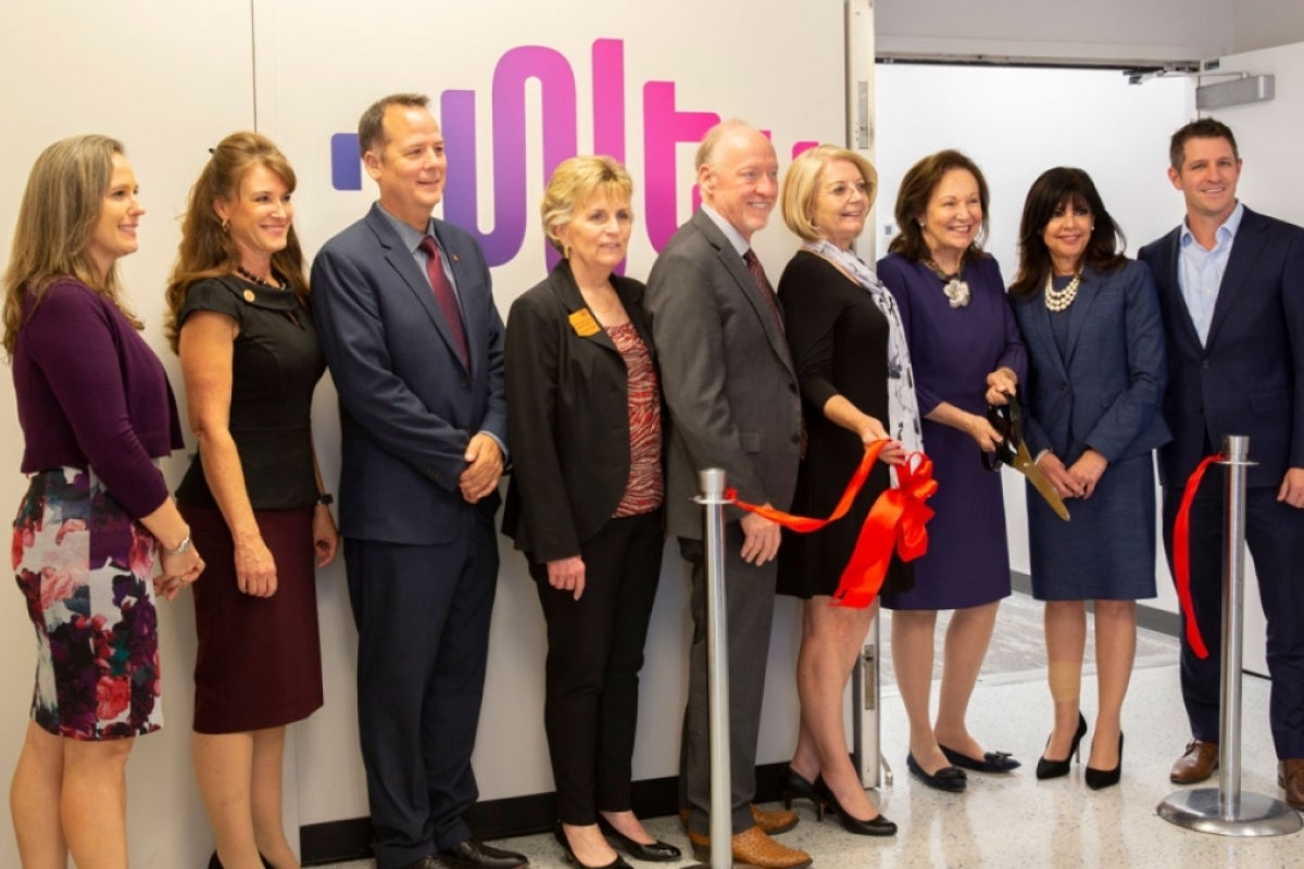 Local government, business and economic representatives celebrate the opening of the WearTech Applied Research Center with a ribbon cutting.