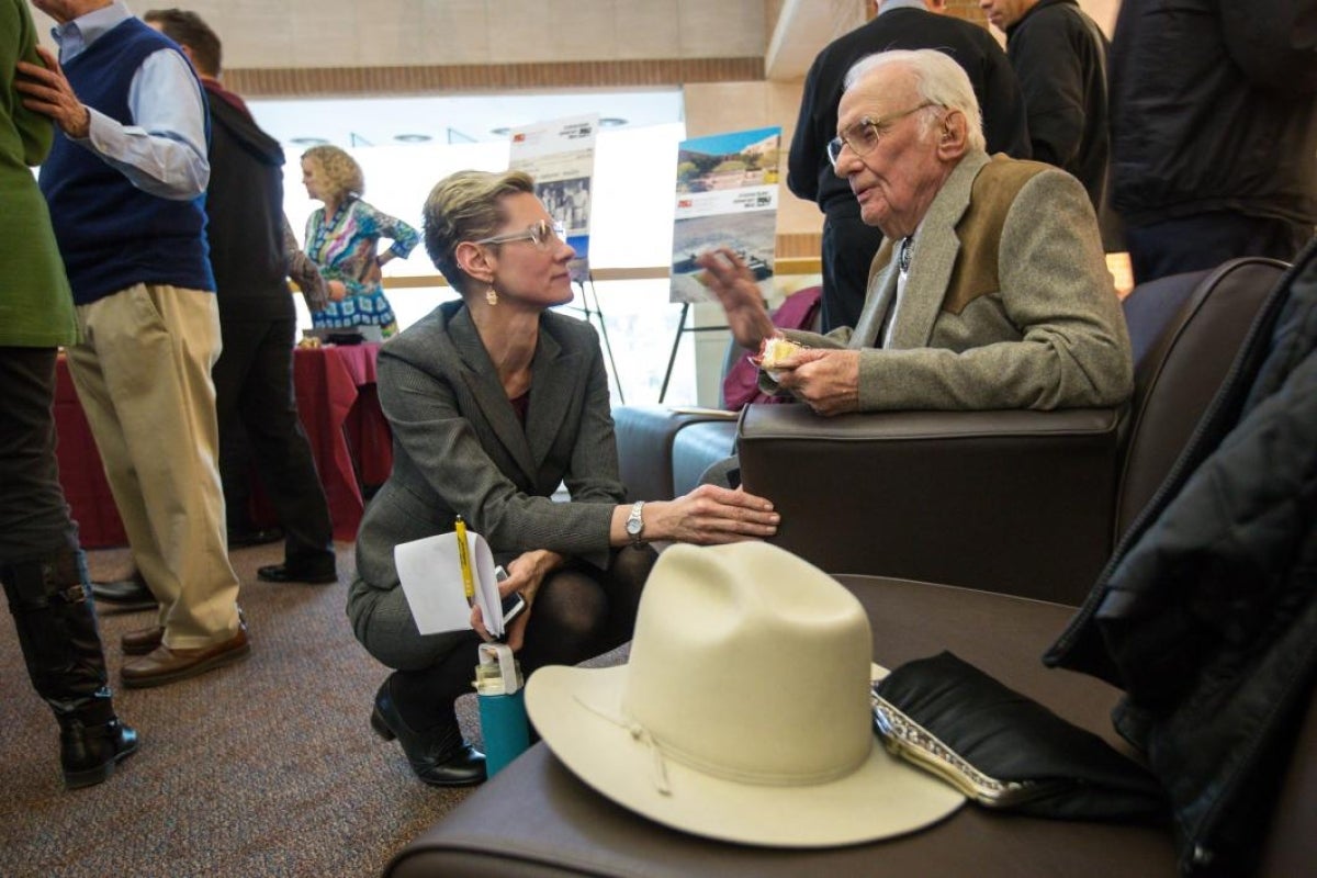 two people speaking in a crowd