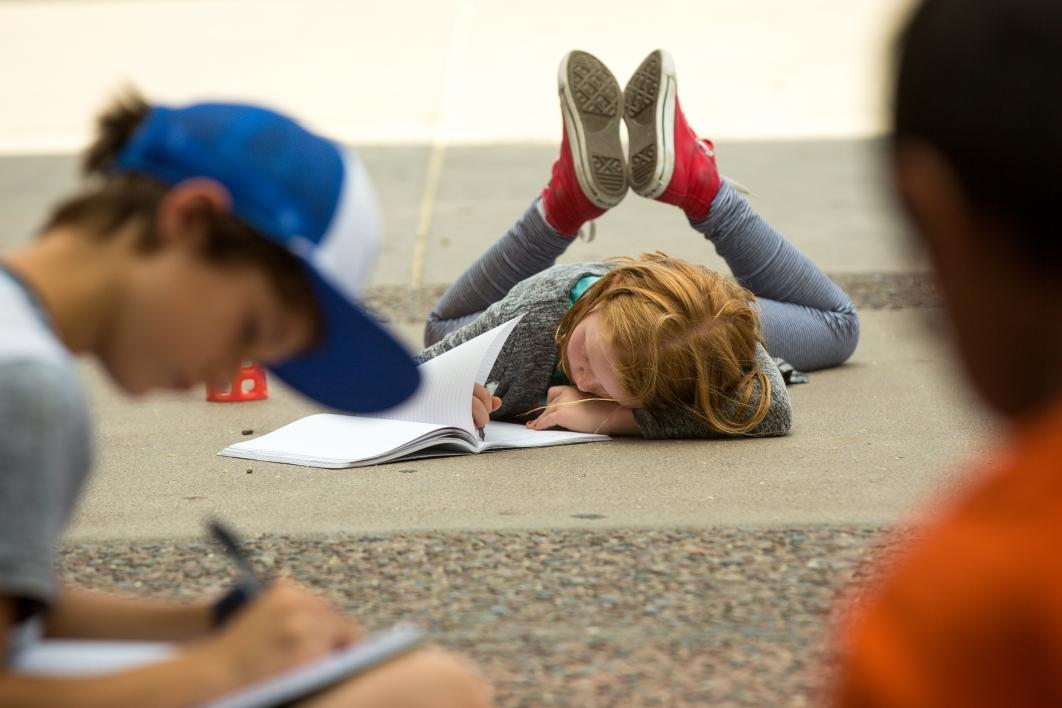 A young student writes during the Young Adult Writing Program